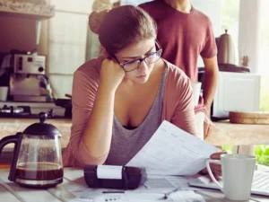 Unhappy stressed young female dressed casually doing domestic budget, paying bills online. Bankruptcy Affects Your Credit Score